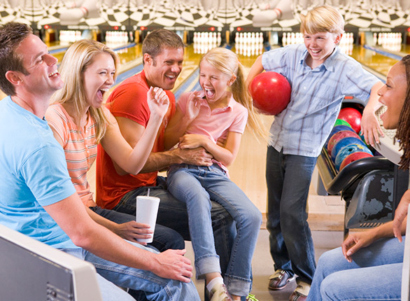 family laughing at bowling alley